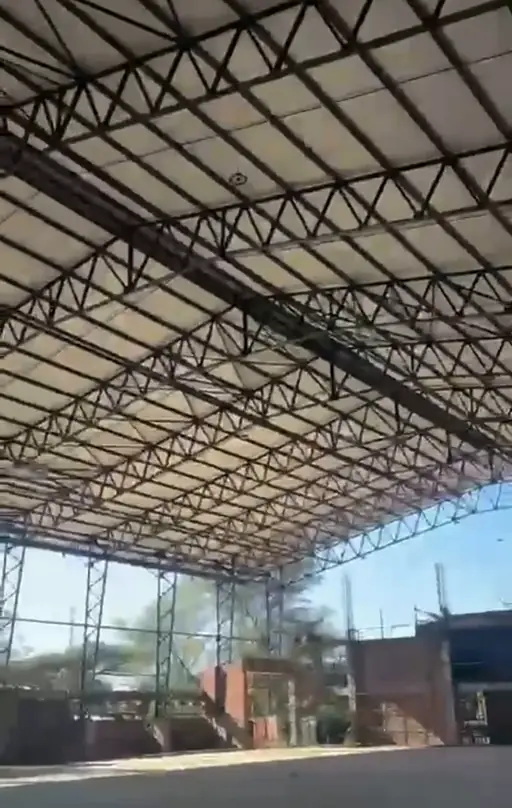 Kingson roof steelwork with trusses and purlins supporting pale sheeting, viewed from inside the structure.